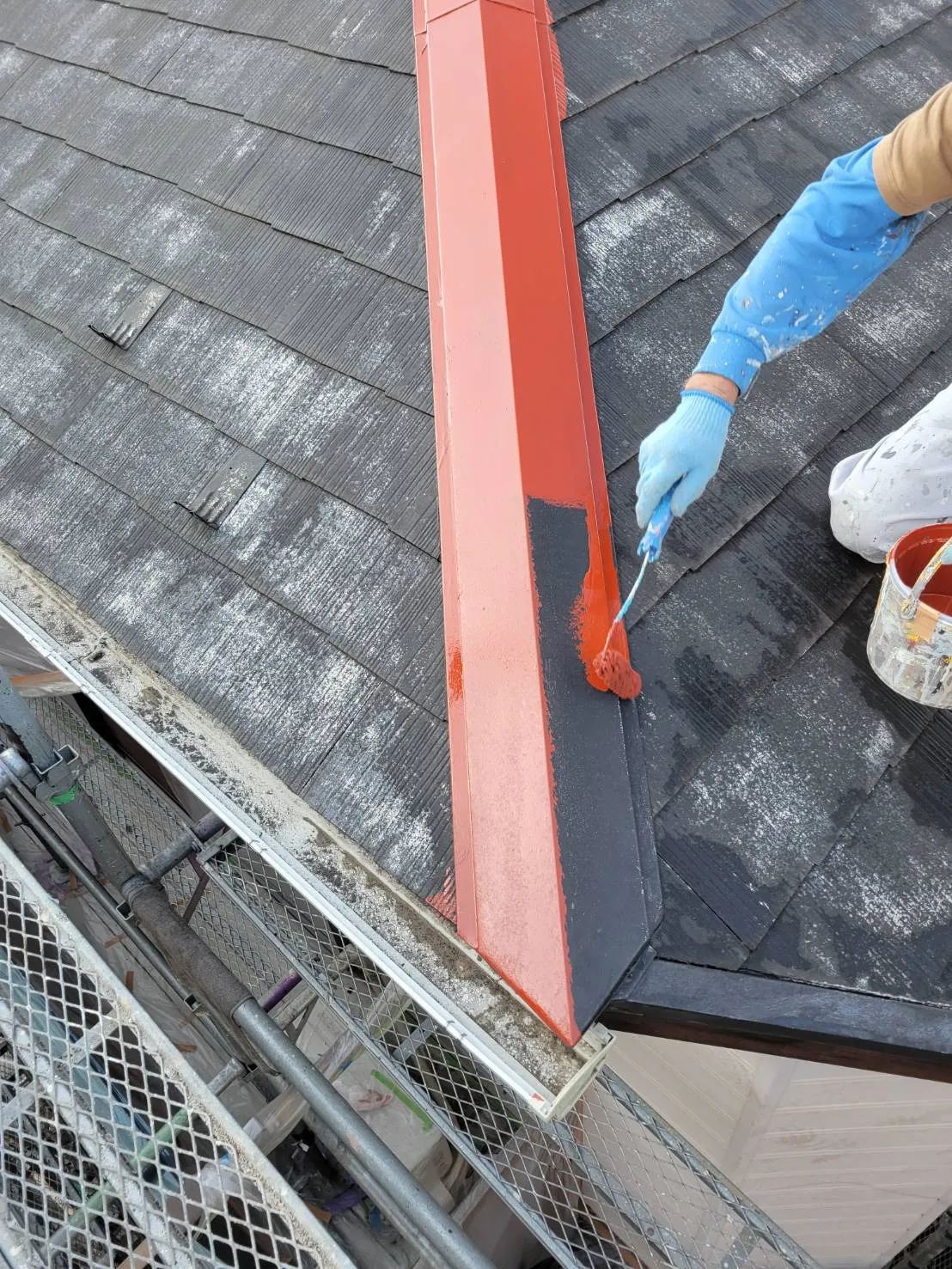 横浜市神奈川区の現場にて屋根の棟押えのさび止め塗り及びシール打ち前の養生テープ貼り