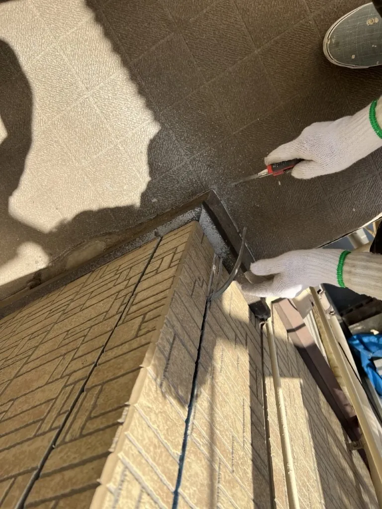 川崎市川崎区東門前にあるA様邸の外壁塗装工事でコーキングを打つための養生作業をしています