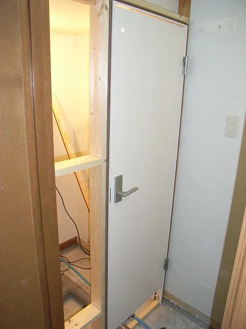 次にトイレと給湯室の区切りに扉を取り付けている所（大工工事）